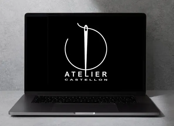 A laptop showing the Atelier logo on screen
