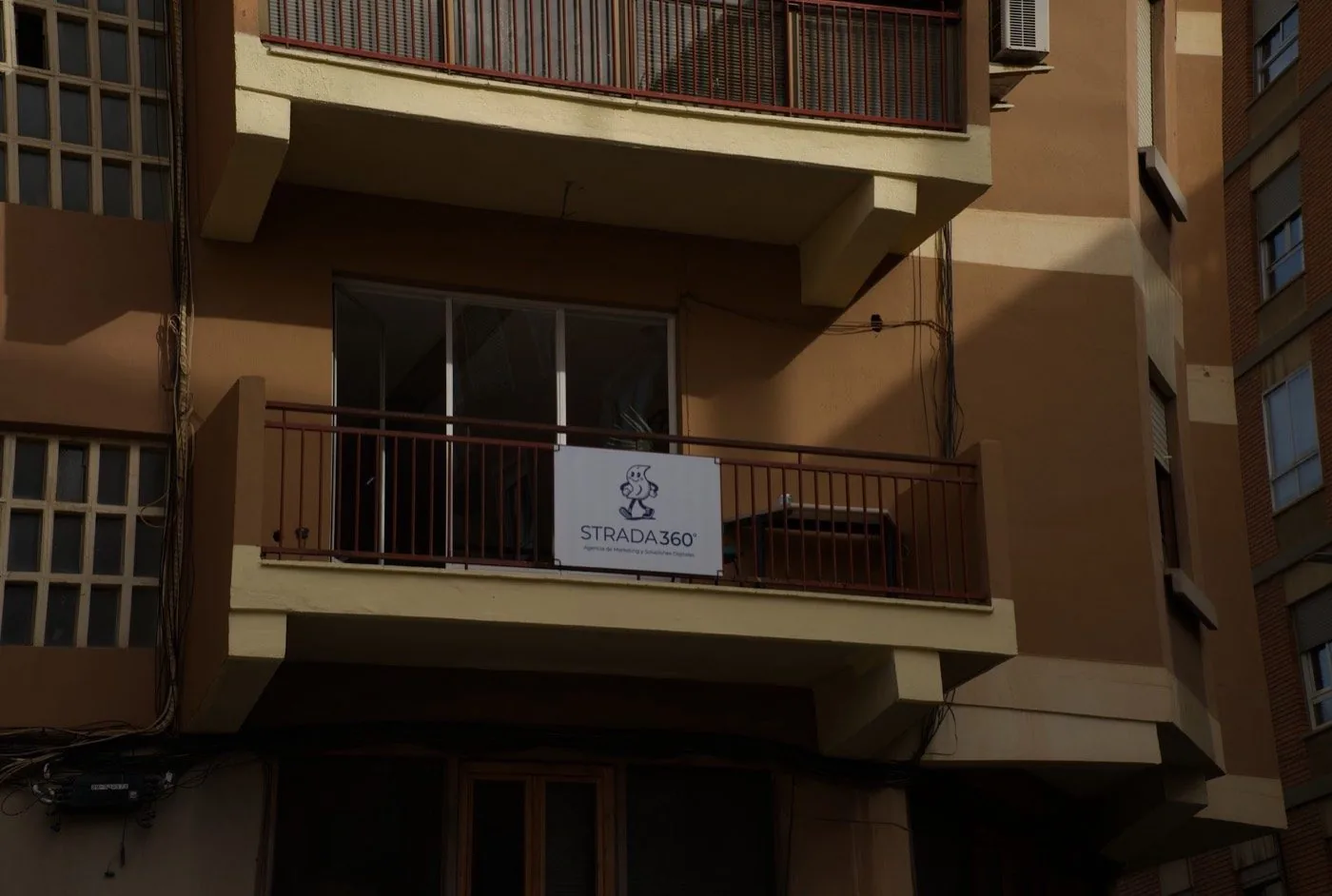 Balcón del estudio con el cartel de STRADA 360