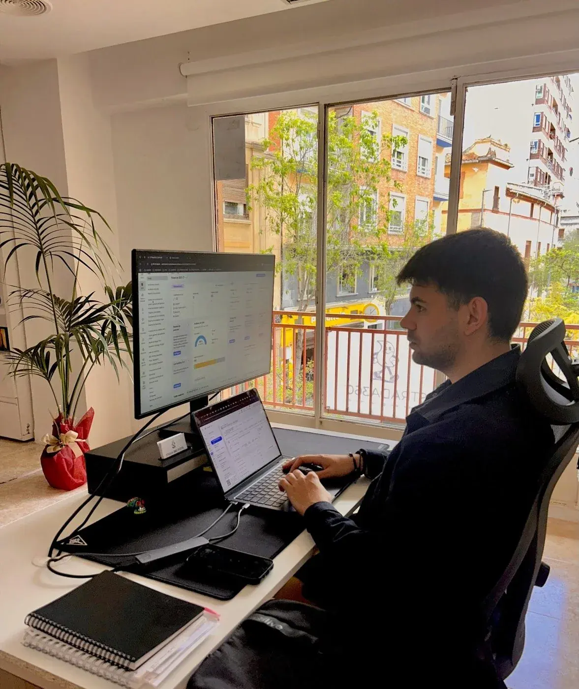 Stefan Valentin, consultor SEO de STRADA 360, trabajando junto a la ventana de la oficina