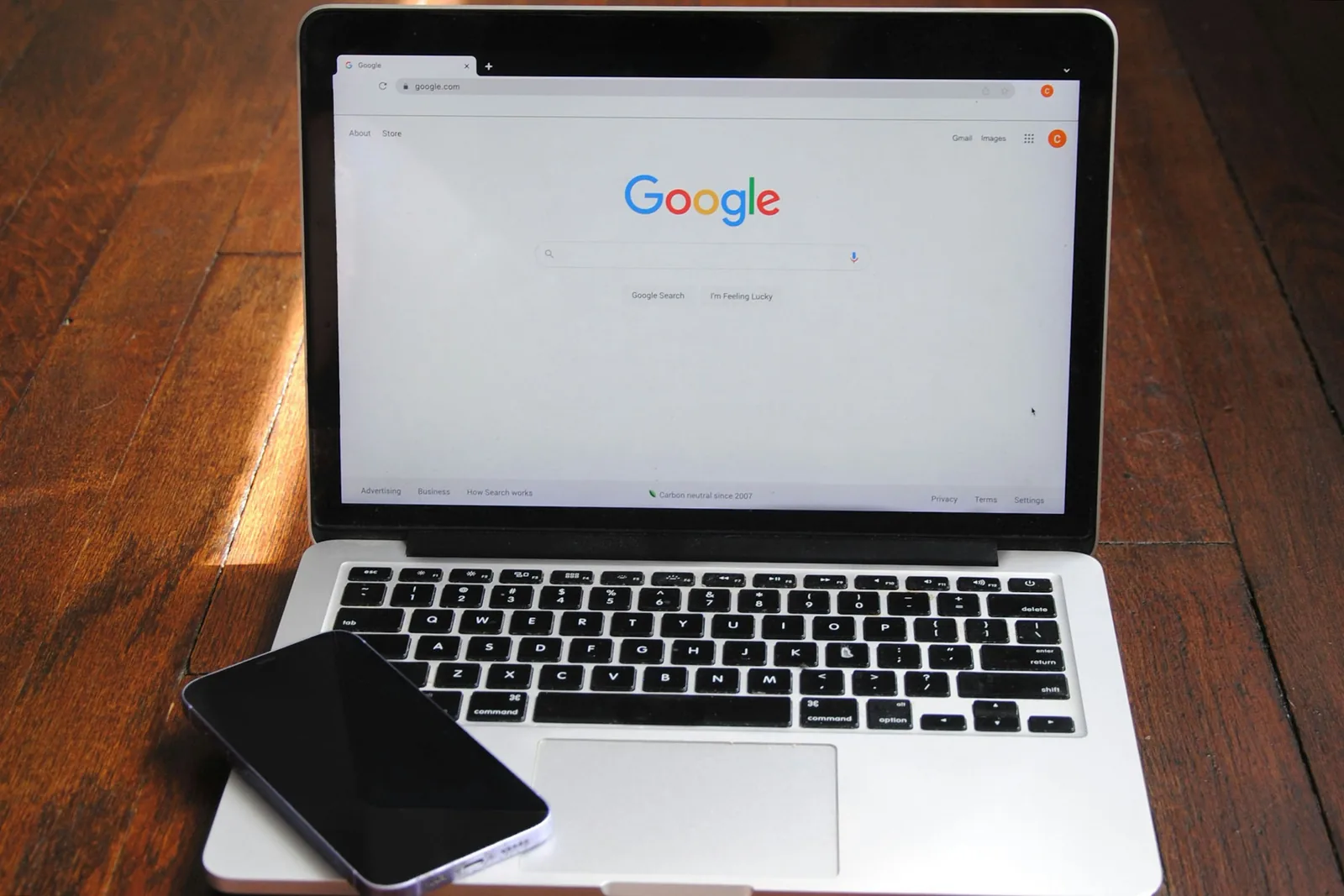Portátil con la búsqueda de Google abierta sobre una mesa de madera